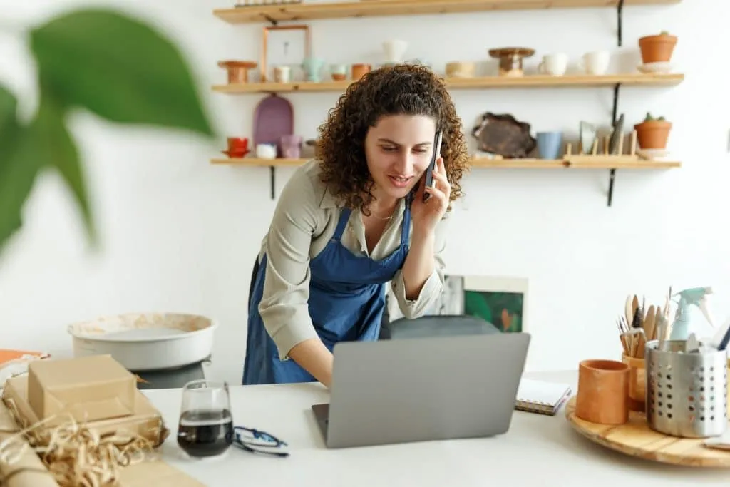 Ondernemer werkt op een laptop in haar atelier